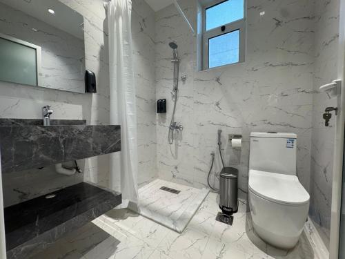 a white bathroom with a toilet and a sink at Najd Cozy Apartments in Dammam
