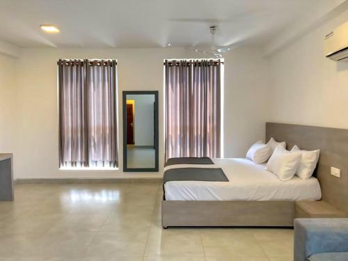 een slaapkamer met een groot bed en een spiegel bij Turtle Beach Hotel Apartment in Mount Lavinia