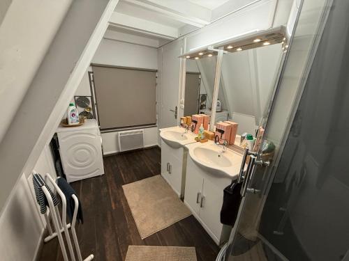 ein Badezimmer mit zwei Waschbecken und einem großen Spiegel in der Unterkunft L'armorique in Saint Die