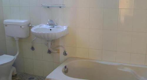 a bathroom with a sink and a tub and a toilet at Mystique Highland Resort in Astam
