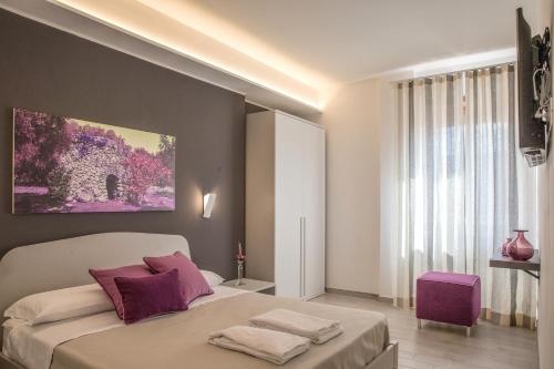 um quarto com uma cama grande e almofadas roxas em NovantaNove B&B em Lecce