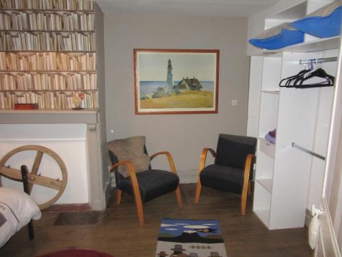 a living room with two chairs and a fireplace at p'tite maison entre mer et campagne in Wimille