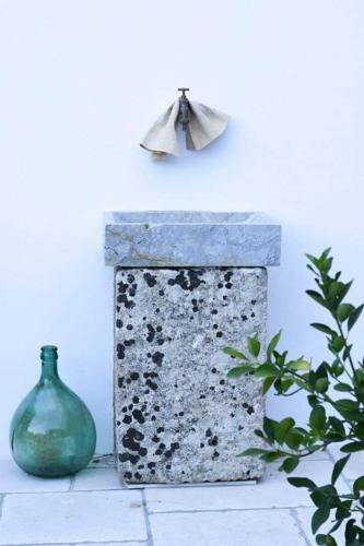 a vase and a stone box sitting on a table at Masseria Convento in Novoli