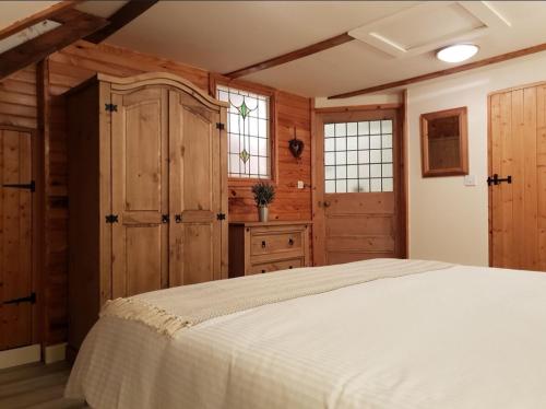 una camera da letto con un letto bianco e pareti in legno di L'Echappée Normande a Saint-James