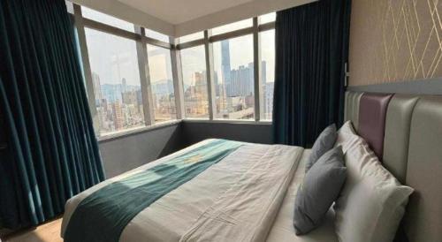 Un dormitorio con una cama con una ventana grande. en Metro Winner Hotel, en Hong Kong