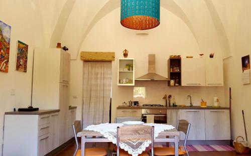 cocina con mesa y sillas en una habitación en Masseria Convento, en Novoli