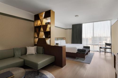 a hotel room with a bed and a couch at The Printing House Hotel, Tapestry Collection By Hilton in Nashville