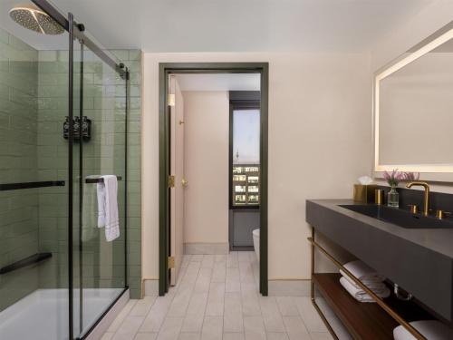 a bathroom with a sink and a glass shower at The Printing House Hotel, Tapestry Collection By Hilton in Nashville