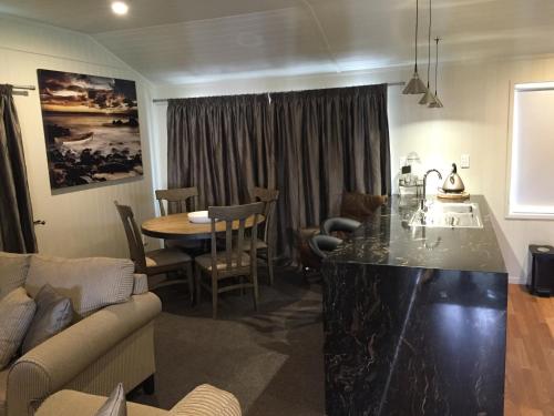a kitchen and living room with a table and a couch at Rocky Mountain Chalets Ohakune in Ohakune