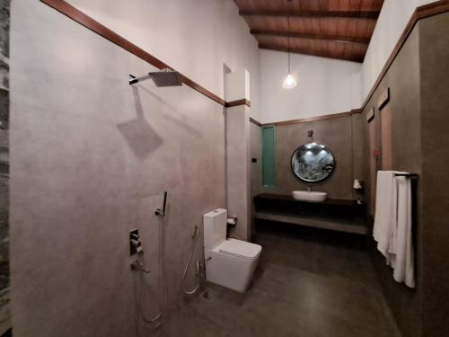 a bathroom with a toilet and a shower and a sink at River Shades Hotel in Hikkaduwa