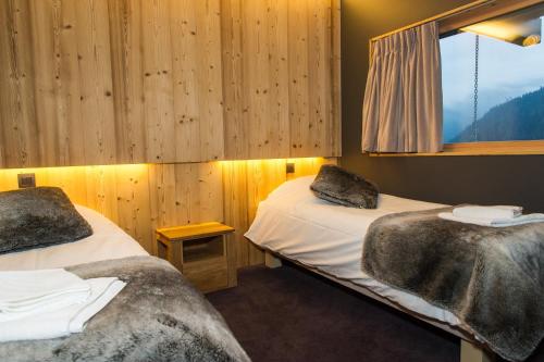 two beds in a room with a window at Chalet du Saix in Châtel