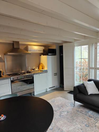 a living room with a table and a kitchen at 't Hofhuys Oss in Oss