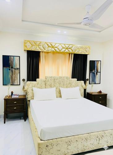 Appartments في فيصل آباد: غرفة نوم بسرير ابيض كبير وطاولتين