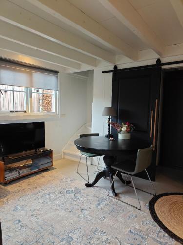 a living room with a table and a television at 't Hofhuys Oss in Oss