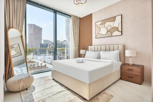 a bedroom with a large white bed and a large window at STAY BY LATINEM Luxury 3BR Holiday Home CA 0702 Near Burj Khalifa in Dubai