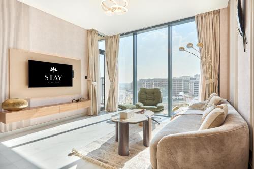 a living room with a couch and a tv at STAY BY LATINEM Luxury 3BR Holiday Home CA 0702 Near Burj Khalifa in Dubai