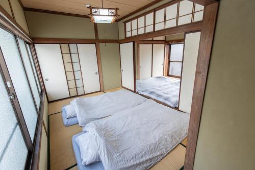 a small room with two beds and a window at 御太刀屋 in Oishi