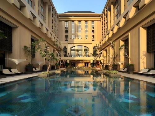 a swimming pool in the middle of a building at Hotel Tentrem Yogyakarta in Yogyakarta