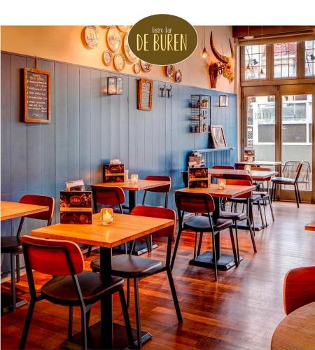a dining room with tables and chairs in a restaurant at Slapen bij De Buren in Alkmaar