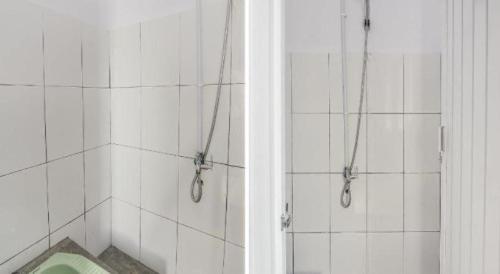 Hotel O 3m Kost Dan Homestay في Paniki-atas: حمام من البلاط الأبيض مع دش ومرحاض