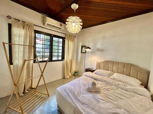 Un dormitorio con una cama y una lámpara de araña en Chic Double Room Shared Bungalow near LRT SS1 PJ, en Petaling Jaya
