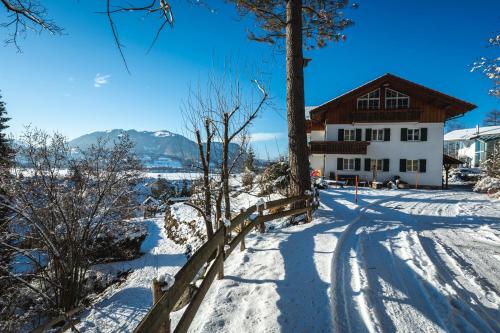 a house in the snow with a fence at Waldchalets & Ferienwohnungen Allgäu in Burgberg