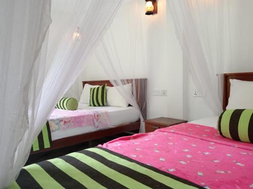 um quarto com duas camas e um dossel em Forest Paddy Homestay em Ella