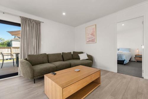 a living room with a couch and a coffee table at Within Range in Papamoa
