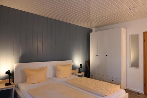 a bedroom with a white bed with yellow pillows at Dünenhaus Fewos - Zum Strand 50m in Ueckeritz