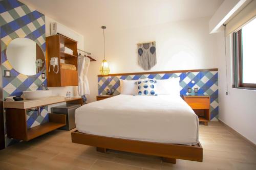 Nuxká Hotel في تيلشاك بويرتو: غرفة نوم بها سرير ومكتب ومغسلة