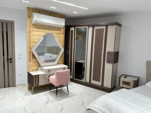 a bedroom with a vanity and a mirror and a chair at Studio pearl pyramids in Ghaţāţī