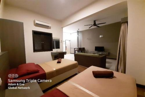a hotel room with a bed and a tv at OYO Home 90416 Exclusuites in Melaka
