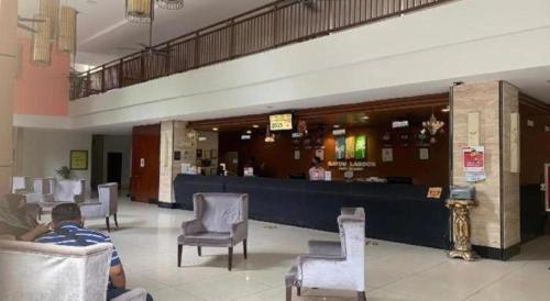 a man sitting in a chair in a waiting room at OYO Home 90416 Exclusuites in Melaka