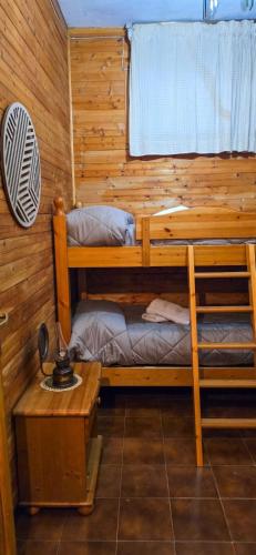 een kamer met 2 stapelbedden en een tafel bij Cuore della Sila Apartment in Camigliatello Silano