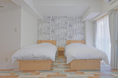 a bedroom with two beds and a wall with graffiti at Wallaby House in Kawaguchi