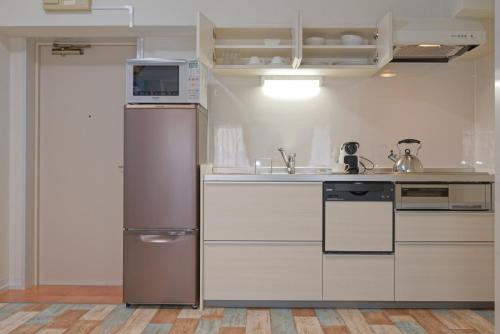 a kitchen with a refrigerator and a sink at Wallaby House in Kawaguchi