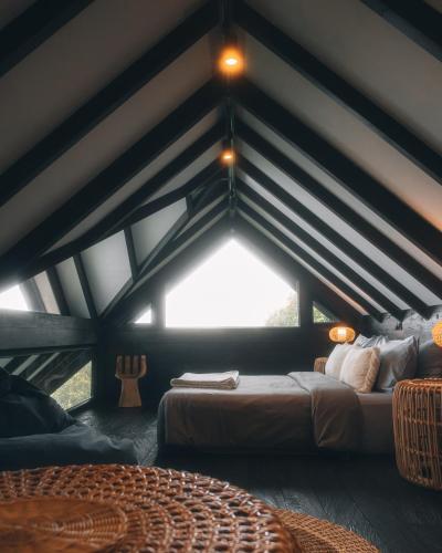 a bedroom with a large bed in a attic at Wanagiri Cabin in Gitgit