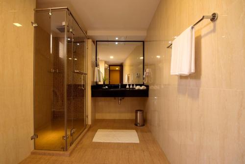 bagno con doccia in vetro e lavandino di Champa Central Hotel a Città di Malé