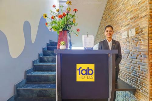 a woman standing behind a podium next to a brick wall at Via Blue Moon Residency in Chennai