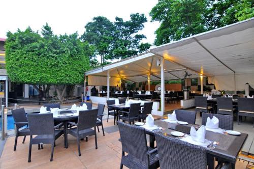 an outdoor restaurant with tables and chairs and aophe at Enrise by Sayaji Bhopal in Bhopal