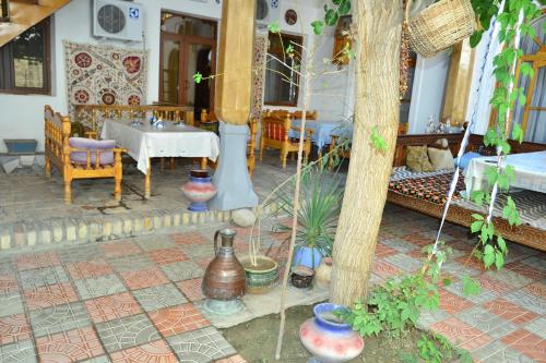 a dining room with a table and some plants at Hotel Nazira & Azizbek in Bukhara