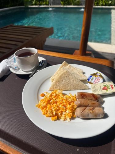 ein Teller mit Essen auf einem Tisch mit einer Tasse Kaffee in der Unterkunft Wanaseta Guesthouse in Uluwatu