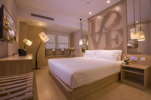 een slaapkamer met een groot wit bed in een kamer bij Orange Hotel Suzhou Emerald Plaza in Suzhou