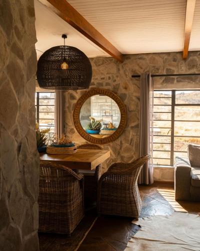 a stone room with a table and a mirror at Twyfelberg Karoo Hideaway in Britstown