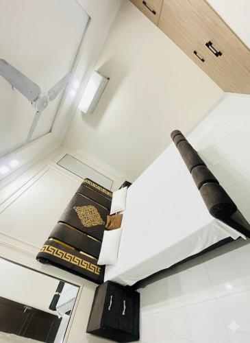 une chambre blanche avec un lit et un grand couteau dans l'établissement Lower canal 1 BHK secure area, à Faisalabad