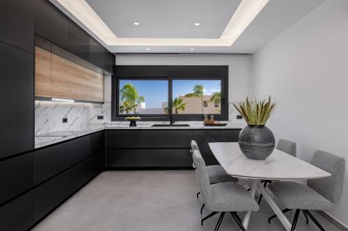 una cocina con mesa y sillas y una ventana en Amani Villas Lindos, en Lindos