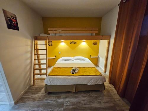 Un dormitorio con una cama con una pared amarilla. en Domaine du Bocage, en Chavagnes-en-Paillers