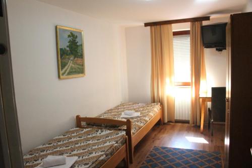 a hotel room with two beds and a television at Hostel S in Novi Sad