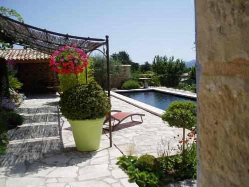 a garden with a bench and flowers and a pool at Le Grangeon in Cruis