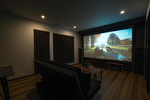 a living room with a large flat screen tv at Guest House TEINE Nisimiyanosawa 41 最大11名滞在 無料駐車場2台完備 TEINE Ski Resort車で15分 in Sapporo